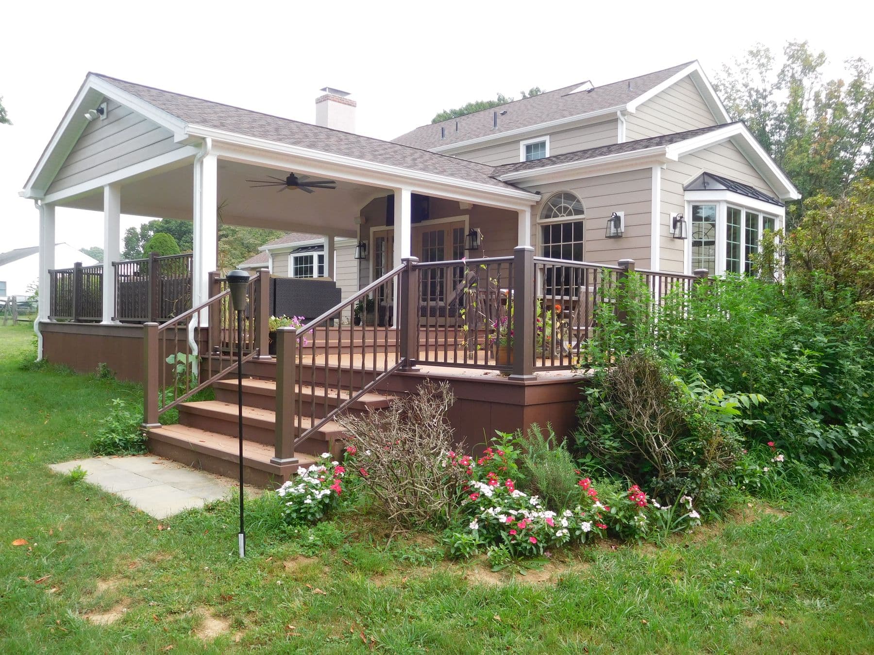 Covered porch addition with composite deck and railing