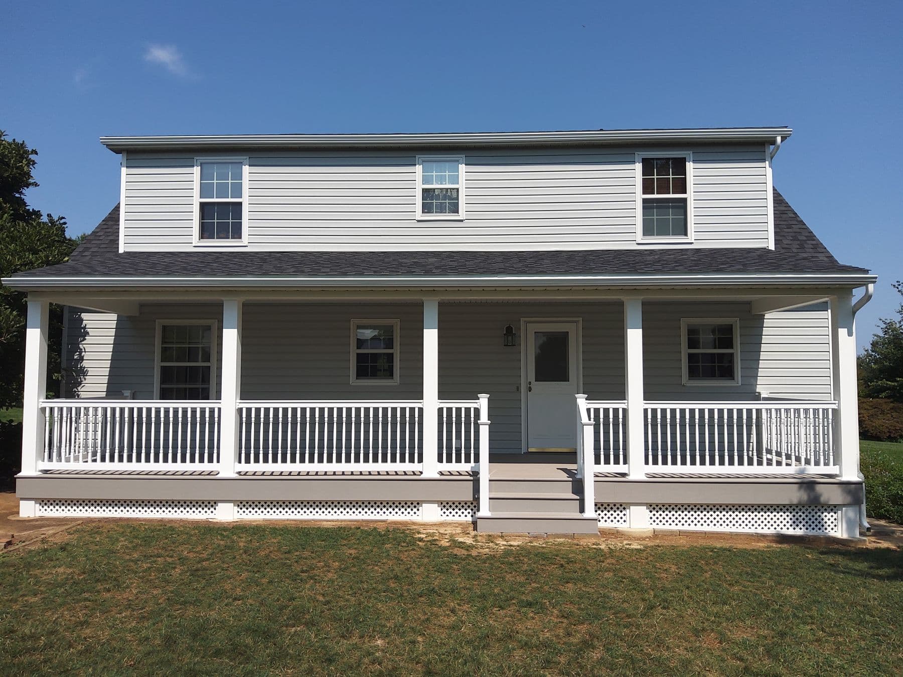 Farmhouse with new siding, porch railing and roof