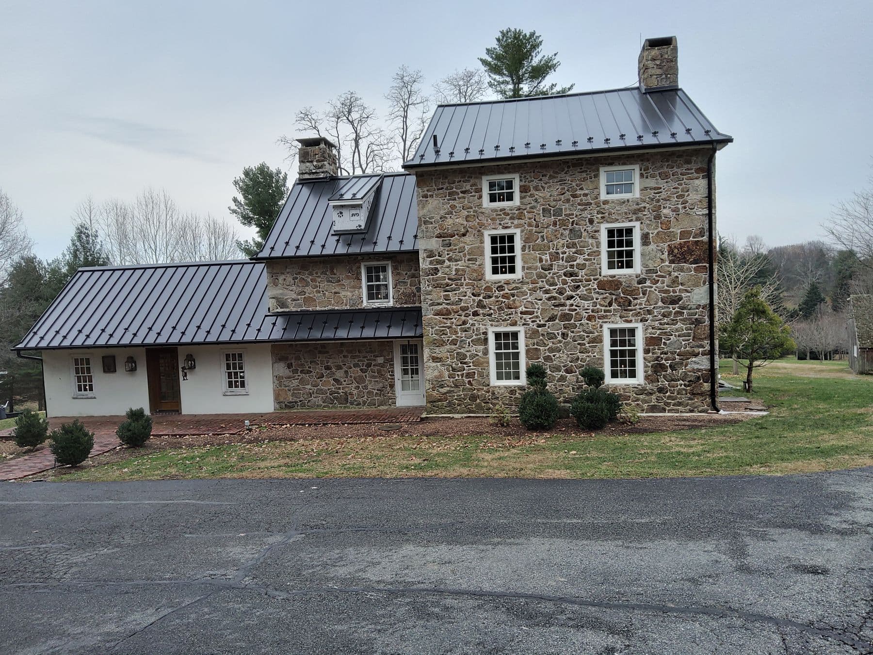 Historic stone house with a new charcoal standing-seam metal roof