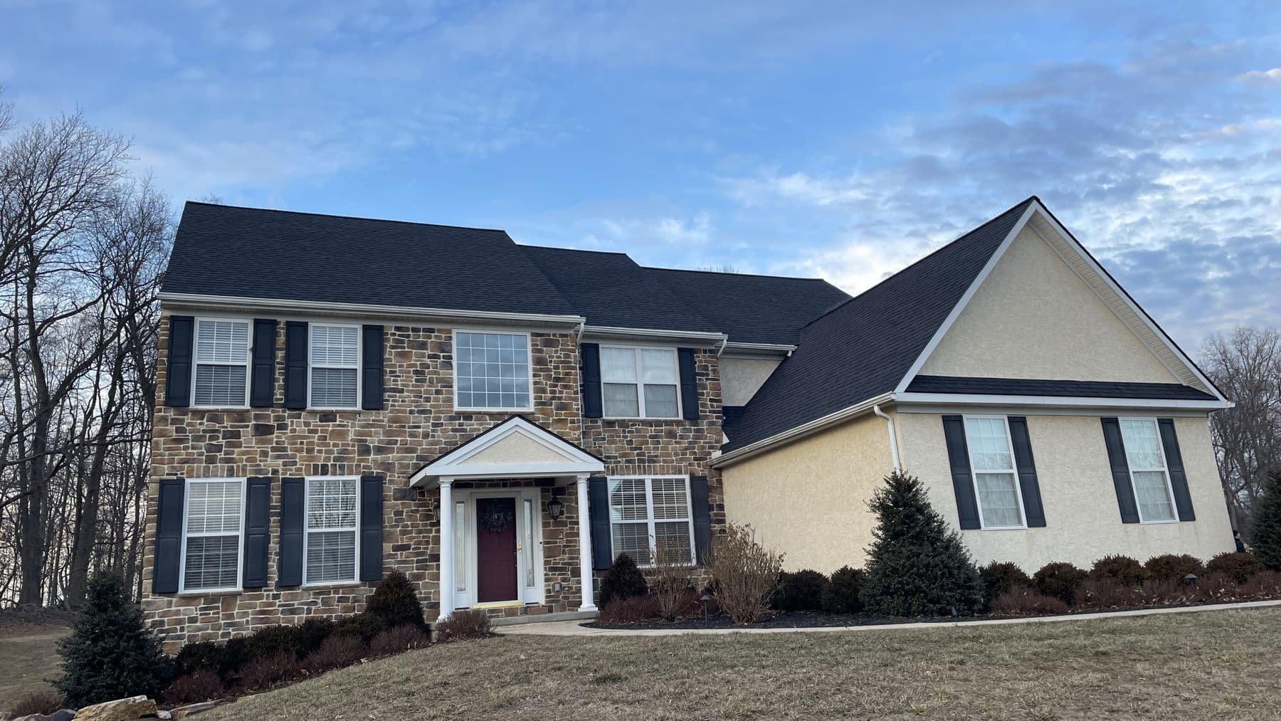 Stone and siding colonial with a new roof by King's